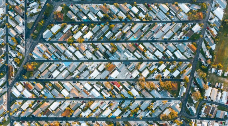 Drone view of modern buildings located in rows between roads in suburb of contemporary town on daytime