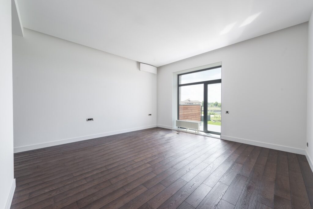Empty room with balcony and parquet floor