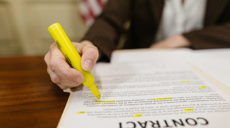 Close-Up Shot of a Person Writing on a Contract