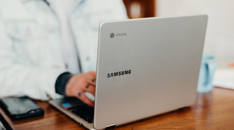 shallow focus photography of person using gray Samsung laptop
