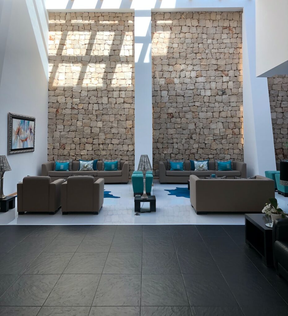 a living room with two couches and a stone wall