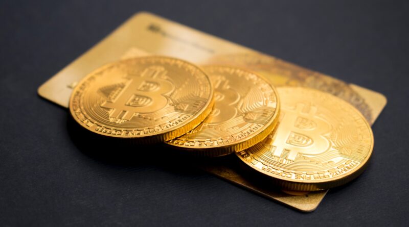 three round gold-colored Bitcoin tokens